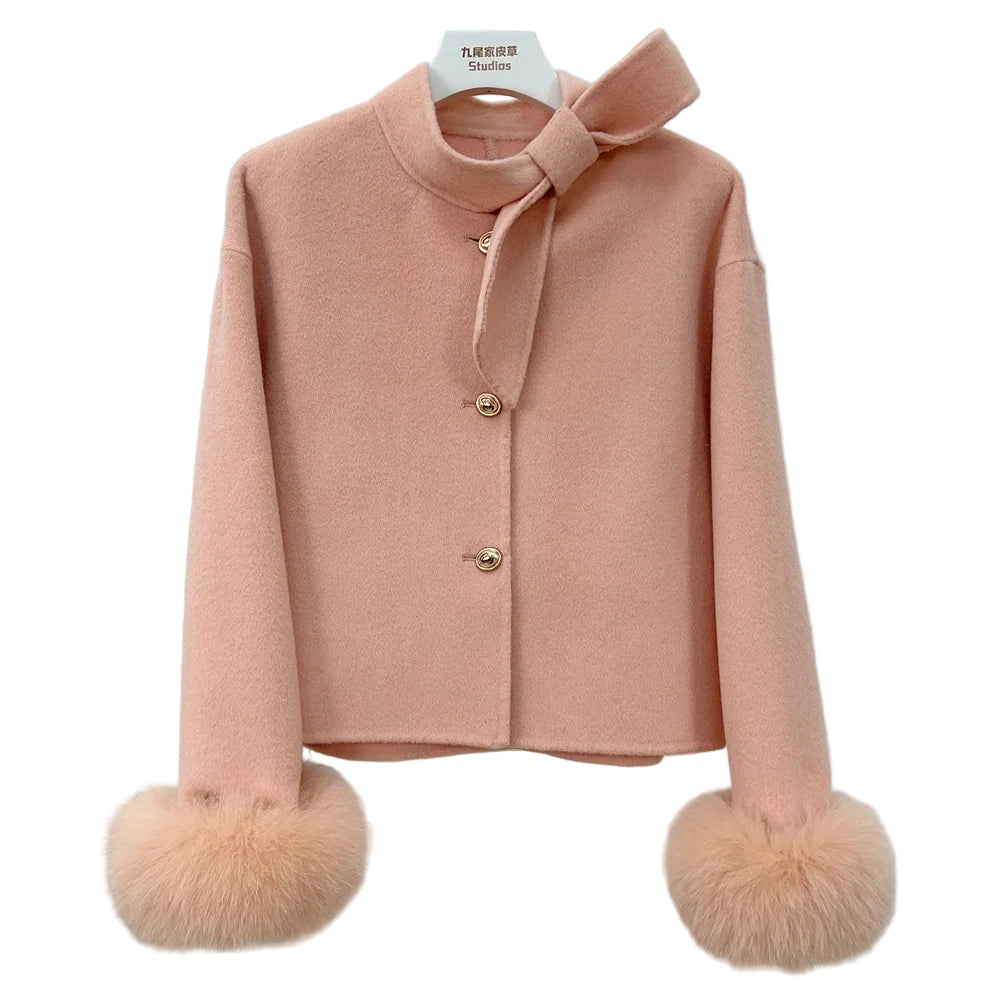 Pink coat with fur pom-poms on a mannequin against a light gray background 