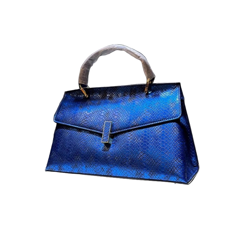 Blue handbag on a white platform with a dark background