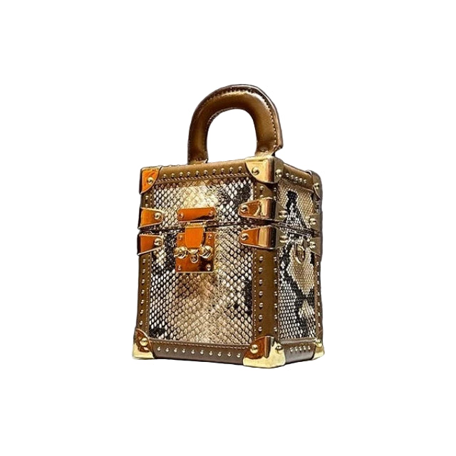 Gold handbag with intricate design on a gray background