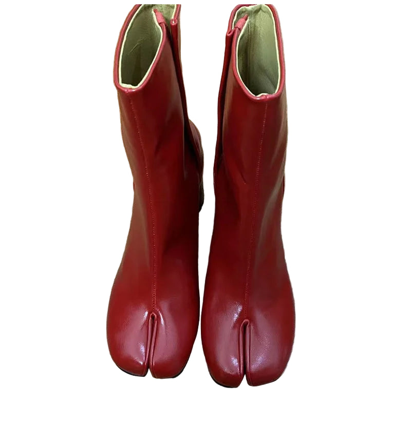 Pair of red tabi boots on a wooden floor