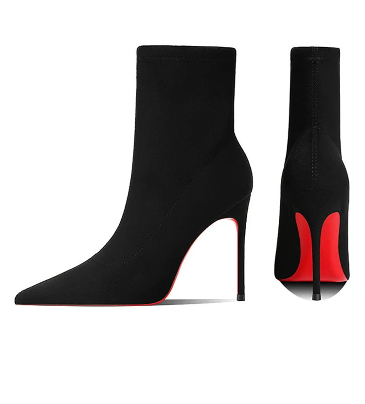 Black high-heeled ankle boots with red accents on a white background